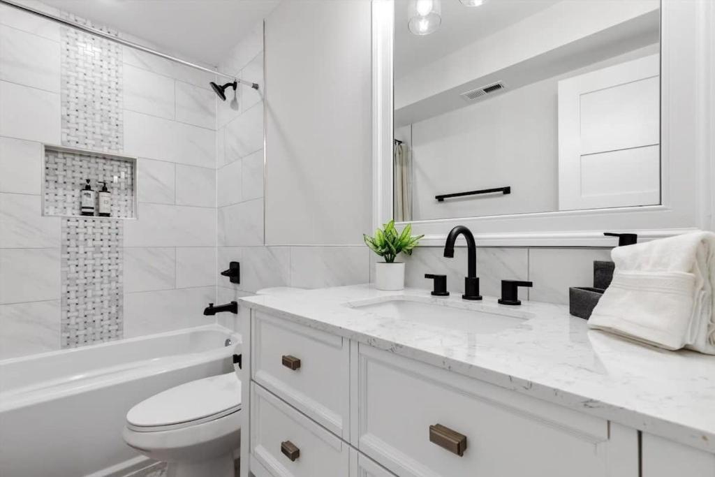 a white bathroom with a toilet and a sink at Excellent 2-BR Condo in Hip Area of DC in Washington, D.C.