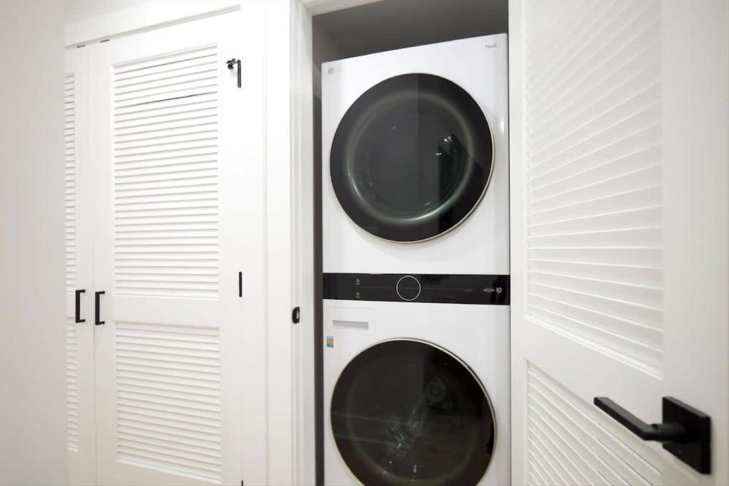 two washer and dryer in a white closet at Excellent 2-BR Condo in Hip Area of DC in Washington, D.C.