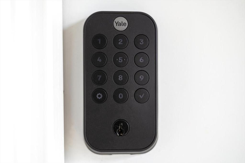 a black remote control sitting on a white wall at Excellent 2-BR Condo in Hip Area of DC in Washington, D.C.