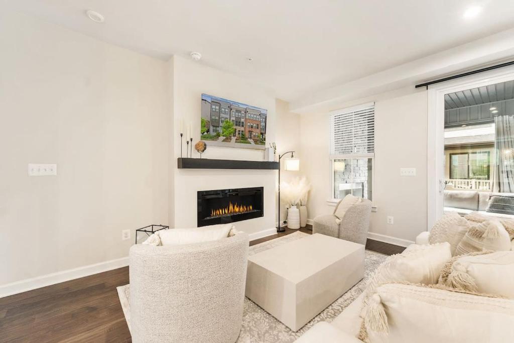 Ashburn 4-BR Homestay Close to Dulles & METRO في Brambleton: غرفة معيشة بأثاث أبيض وموقد