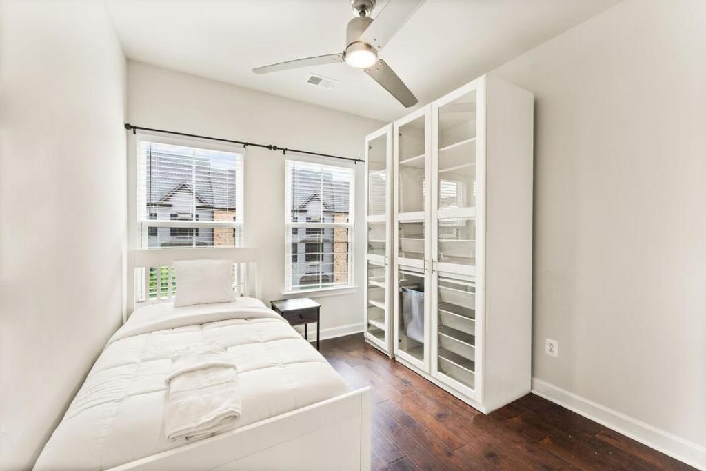 Ashburn 4-BR Homestay Close to Dulles & METRO في Brambleton: غرفة نوم بيضاء مع سرير ونافذتين