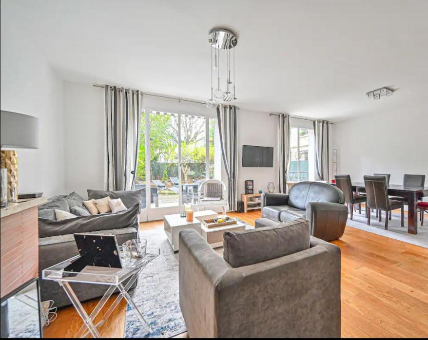 ein Wohnzimmer mit Sofas und ein Esszimmer in der Unterkunft Beautiful 3 bdr apartment with garden close to Champs-Elysées in Neuilly-sur-Seine
