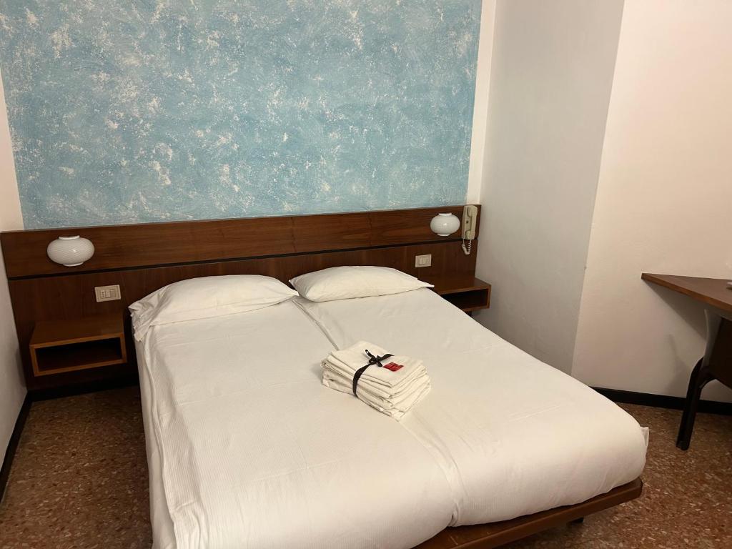 a bed with two white towels on top of it at Albergo da Pina in Lazise