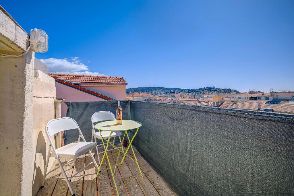une table et deux chaises assises sur un balcon dans l'établissement Maison Bianchi - Jean Médecin, à Nice