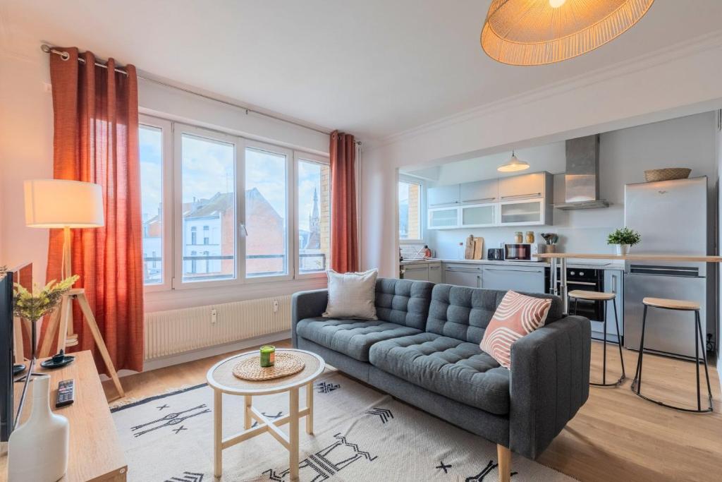 a living room with a couch and a kitchen at One bedroom apartment with balcony, city center in Tourcoing