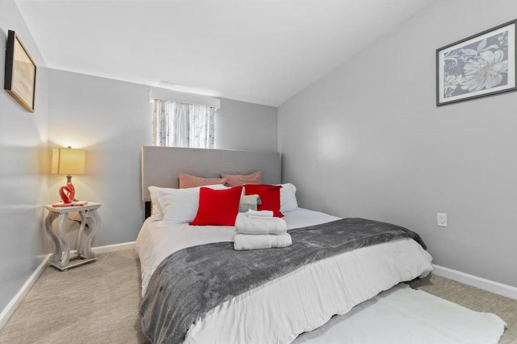a bedroom with a large bed with red pillows at Short Drive to Capitol Hill-Convenient MD Homestay in Capitol Heights