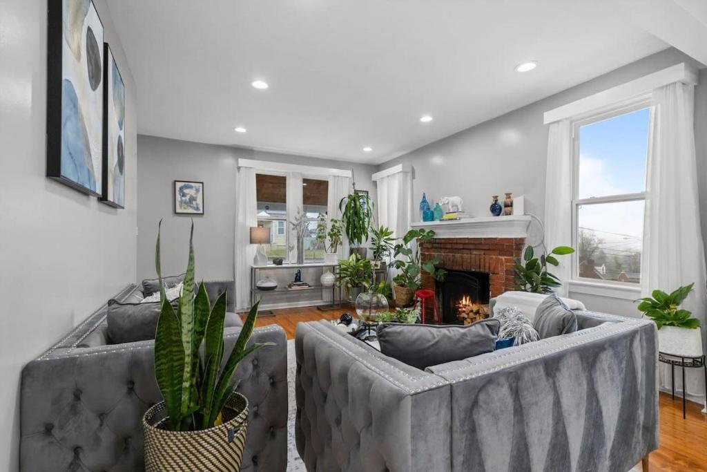 a living room with two gray couches and a fireplace at Short Drive to Capitol Hill-Convenient MD Homestay in Capitol Heights