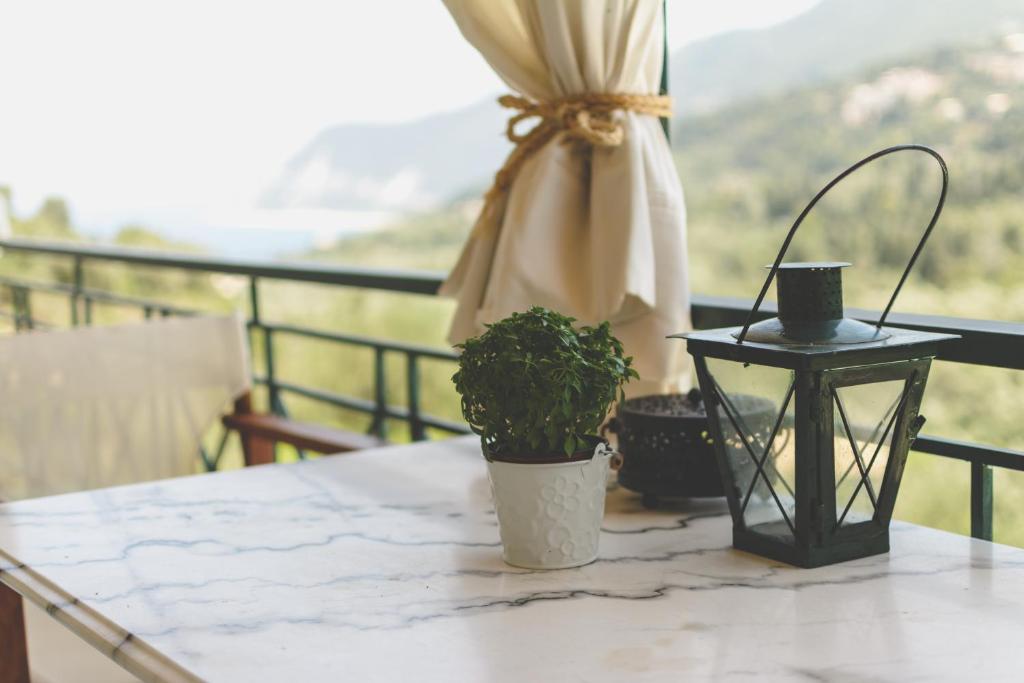 ein Tisch mit einer Pflanze und einer Laterne auf einem Balkon in der Unterkunft Althea Studios Lefkada in Agios Nikitas