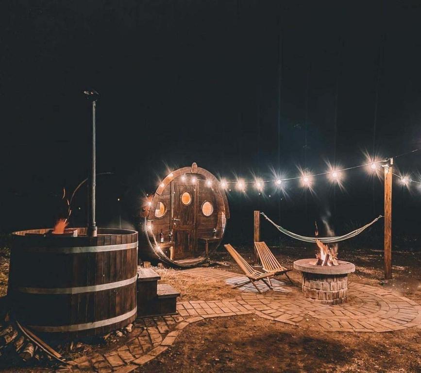 a night scene with a wooden barrel and a playground at Drvena bačva za spavanje in Posušje