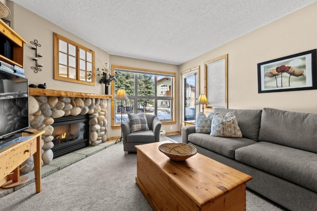 a living room with a couch and a fireplace at Crystal Forest #51 condo in Sun Peaks