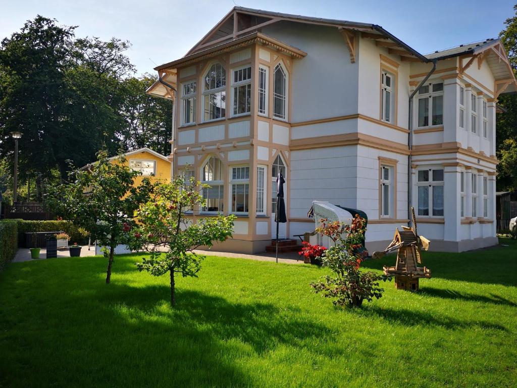 a large house with a green lawn in front of it at Lange am Meer in Heringsdorf