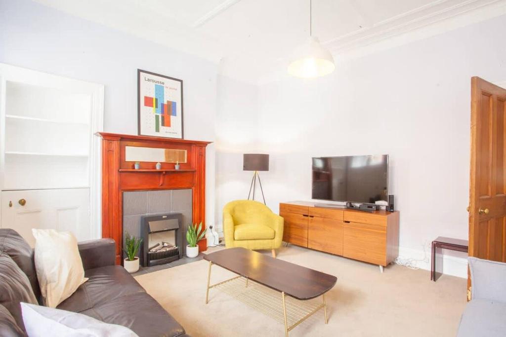 un soggiorno con divano e TV di Modern, Light-filled and Sleek West End Apartment a Glasgow
