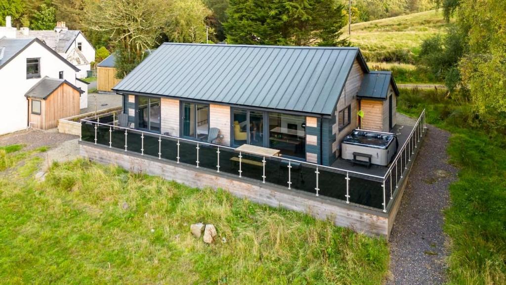 an aerial view of a small house in a field at New Build Lodge With Stunning Views of Loch Awe in Hayfield