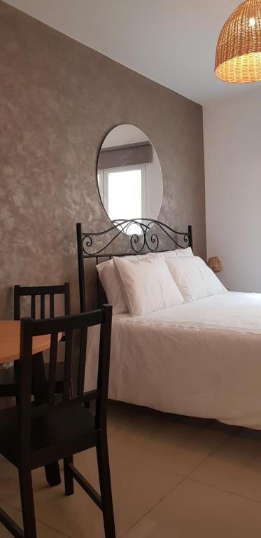 a bedroom with a bed and a mirror and a chair at Bright & modern studio,Sliema in Sliema
