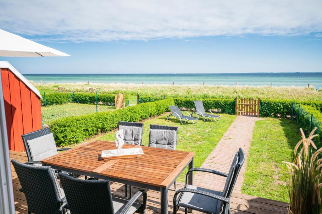 Rettin的住宿－Ocean 1，一个带木桌和椅子的海滩庭院