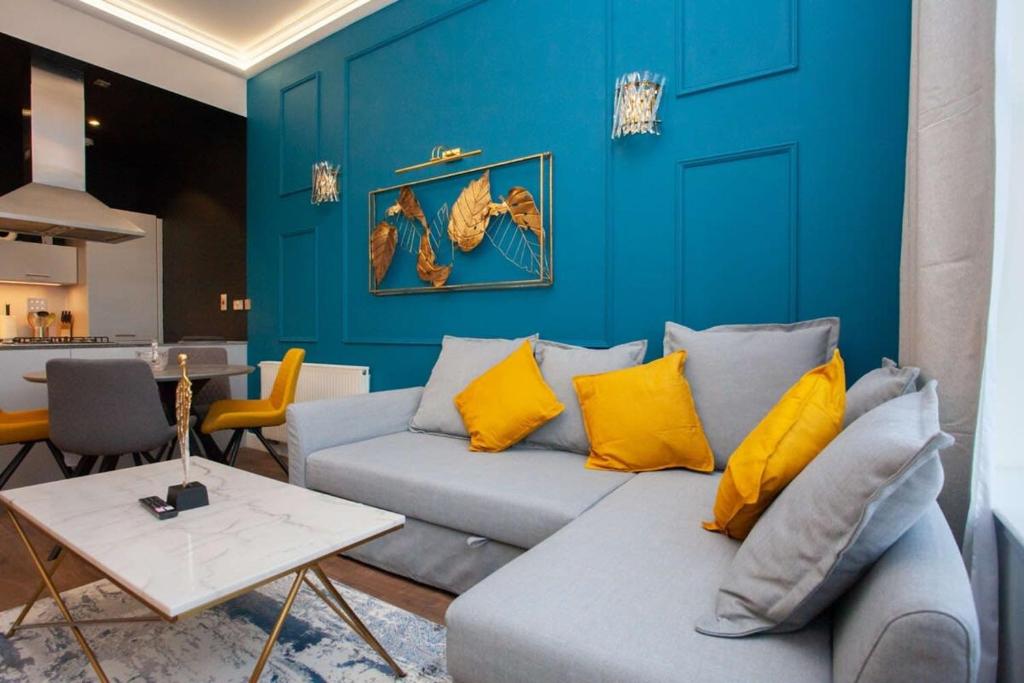 sala de estar con sofá y pared azul en Stunning One bed with parking in City Centre en Glasgow