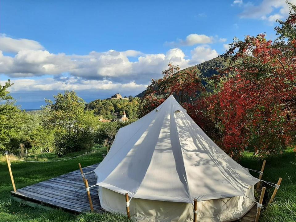 a white tent sitting on a wooden deck at Glamping Cisnadioara in Cisnădioara
