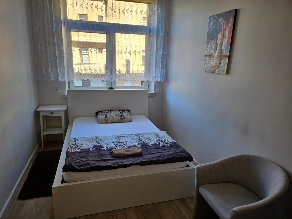 um pequeno quarto com uma cama e uma janela em Centre kambarys su didele lova #1 em Kaunas