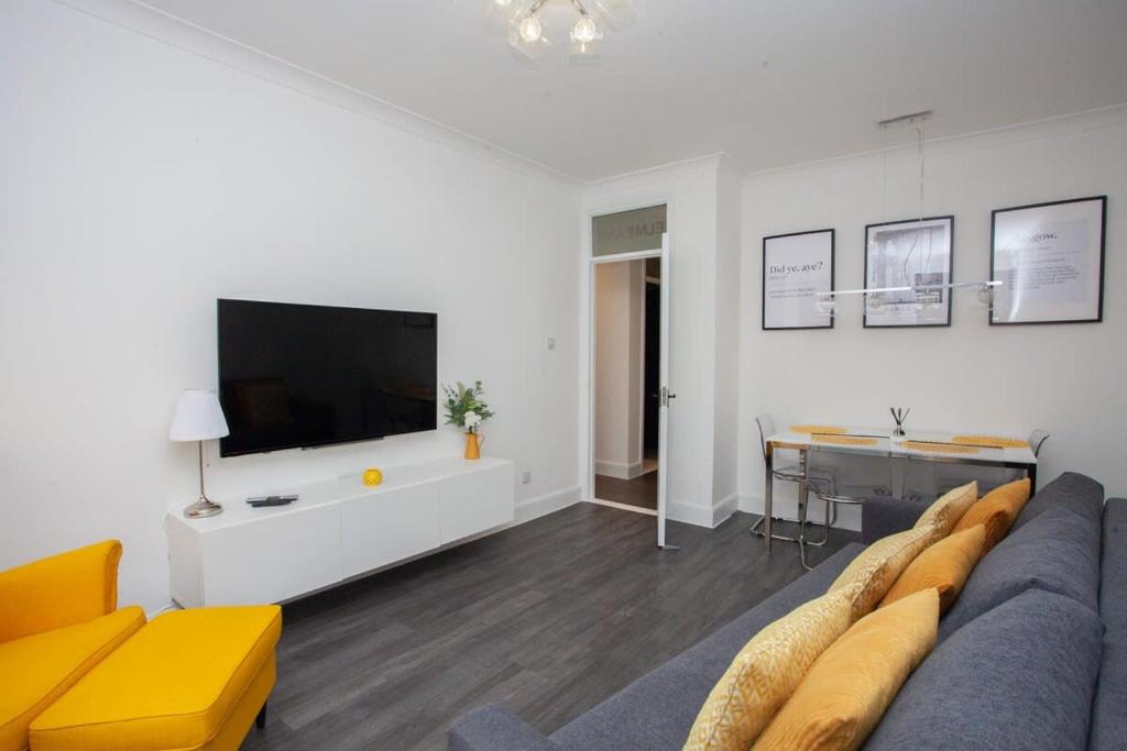 a living room with a couch and a flat screen tv at Newly Renovated City Apartment in Glasgow