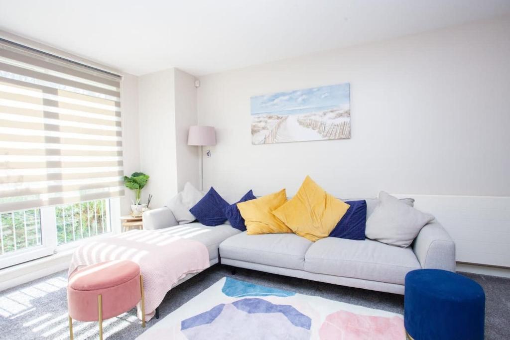 uma sala de estar com um sofá e uma mesa em Stunning 3 Bed Apartment em Bearsden