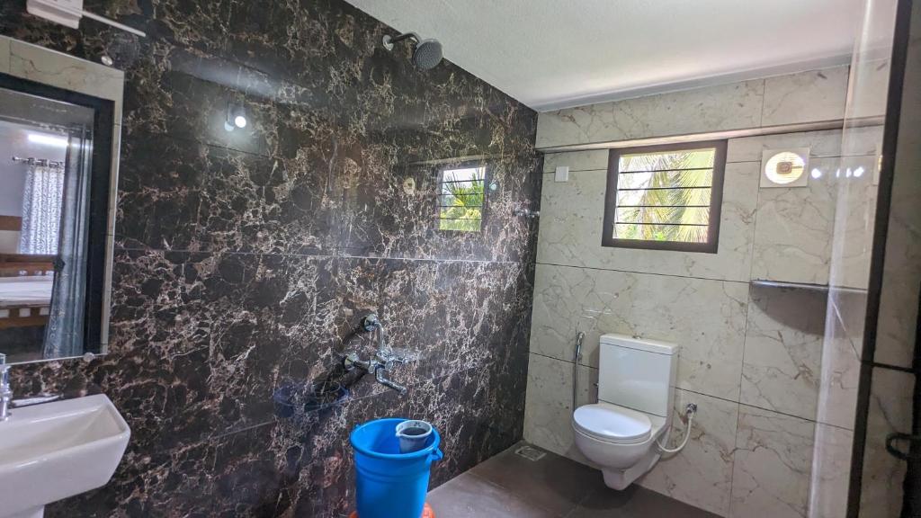 a bathroom with a toilet and a sink at Janardhana Residency in Dharmastala