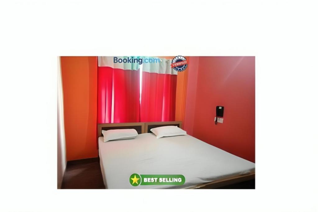 Cama en habitación con pared roja en Hotel Kashi Inn Varanasi By GRG, en Varanasi