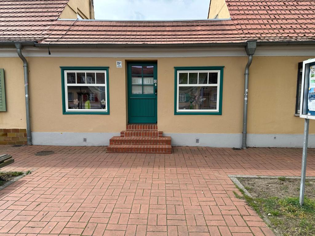 una casa con una puerta verde y ventanas en Smart Home - Die etwas andere Ferienwohnung! en Brandenburg an der Havel