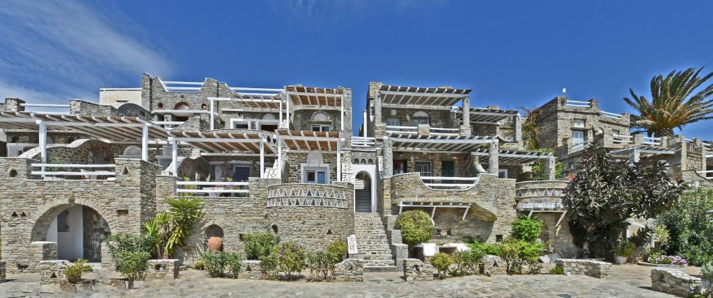 a large stone building with trees in front of it at Artemis Apartments in Tinos
