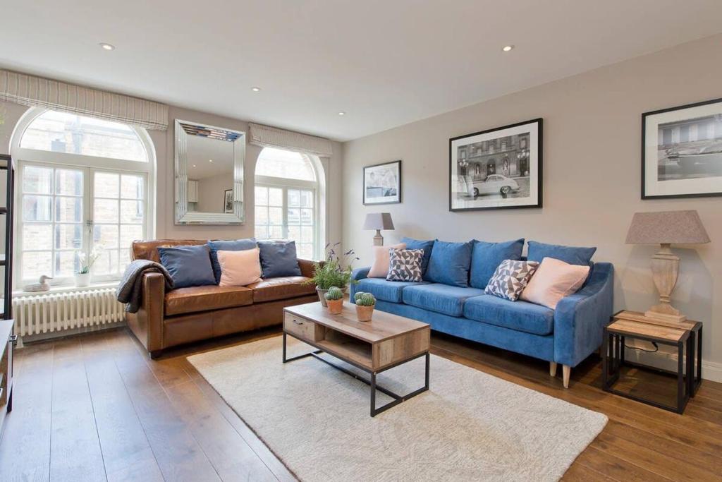 sala de estar con sofá azul y mesa en *Newly Renovated 2-Bed in Heart of Notting Hill*, en Londres