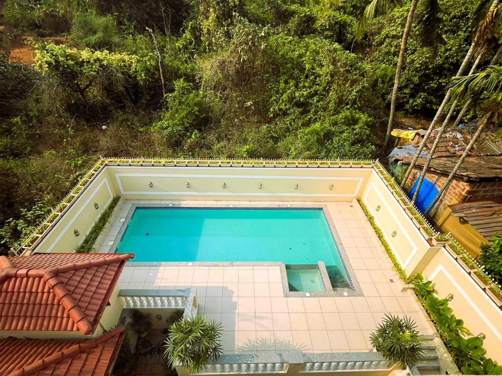 einen Blick über den Pool auf ein Haus in der Unterkunft Cielo in Palolem