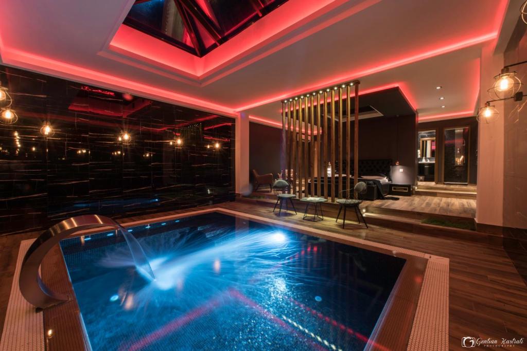 a large swimming pool in a room with a bar at Vera HOTEL-VILLA in Pristina