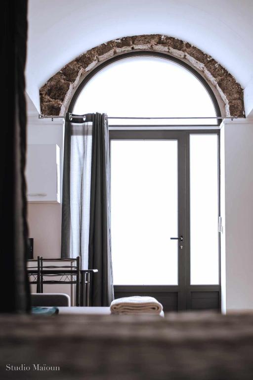 Cette chambre dispose d'une fenêtre et d'une table avec une porte. dans l'établissement Appart cosy, à Sartène