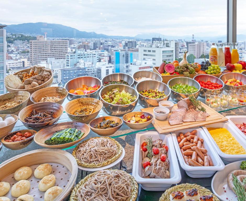 a buffet of food on a table with a view at Hotel JAL City Nagano in Nagano