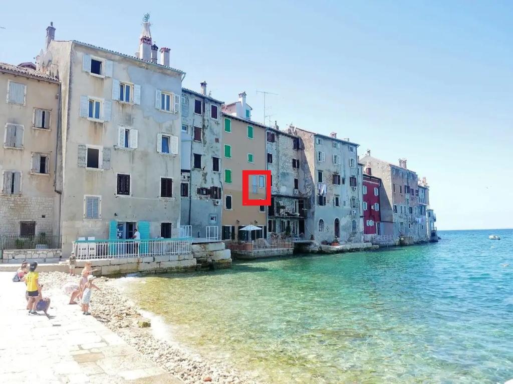 a group of buildings on a beach next to the water at Apartment Stella Marina Sea view Free Parking in Rovinj