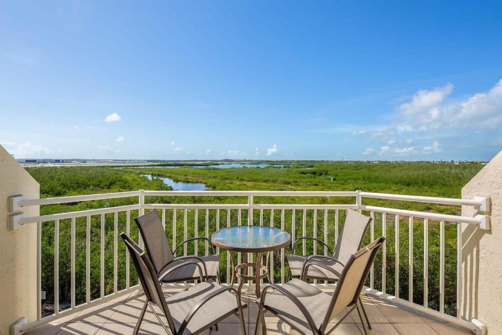 a patio with chairs and a table on a balcony at The Andros by Brightwild-4th Floor Sunset View in Key West