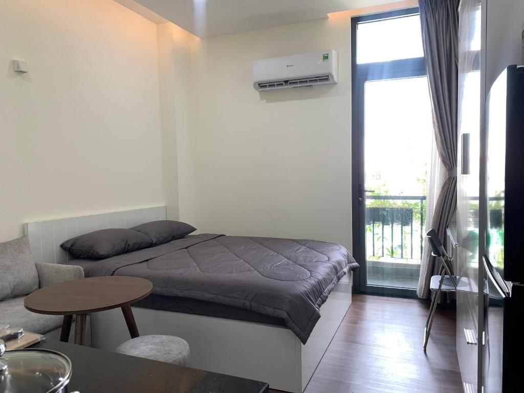 Habitación pequeña con cama y balcón. en LUCY HOTEL & APARTMENT en Ho Chi Minh