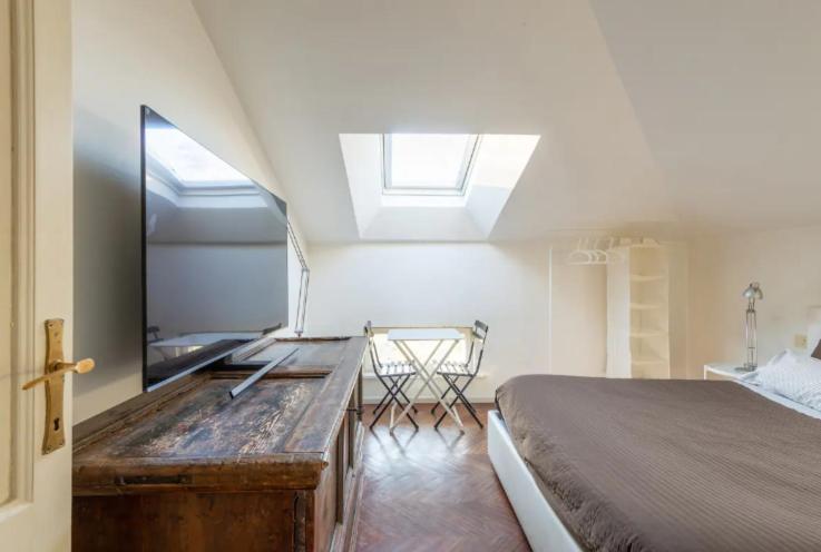 1 dormitorio con cama y tocador con espejo en Heart of Parma - Air Conditioning con posto auto prenotabile, en Parma
