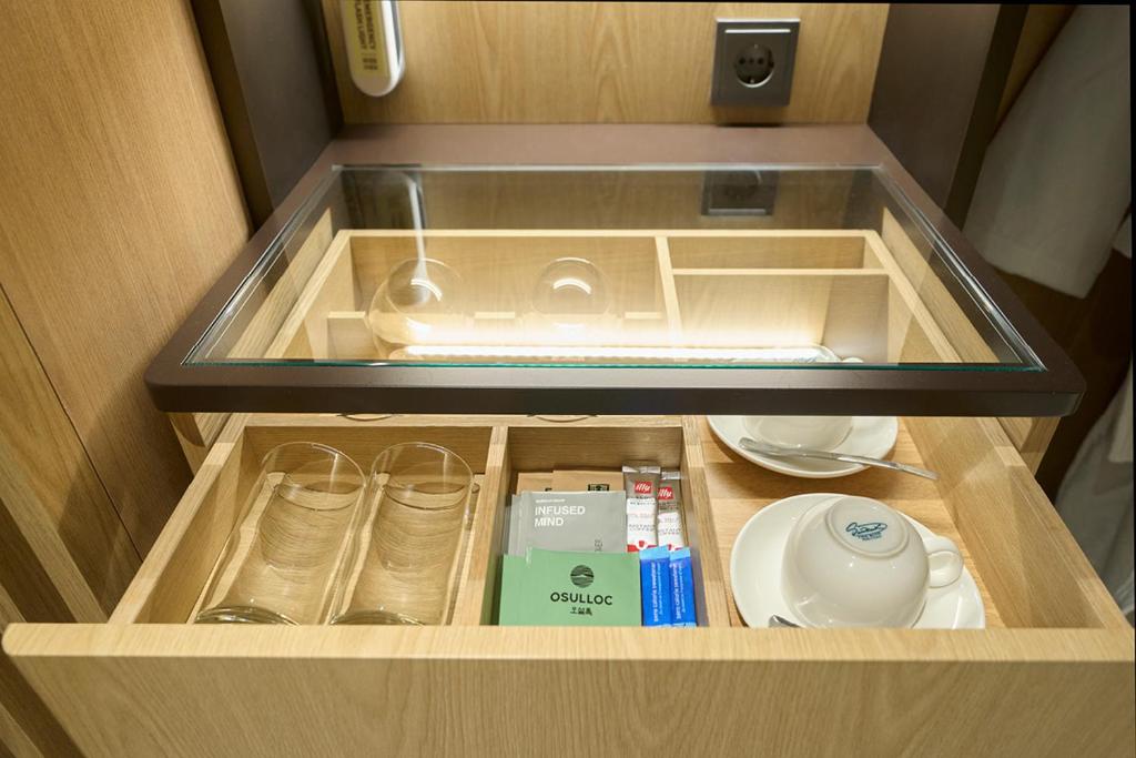 a drawer in a cabinet with a sink and dishes at Mayfield Hotel Seoul in Seoul