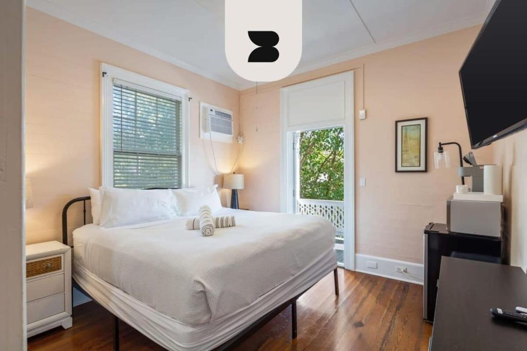 a bedroom with a large white bed and a window at Creme Brulee Suite by Brightwild in Key West