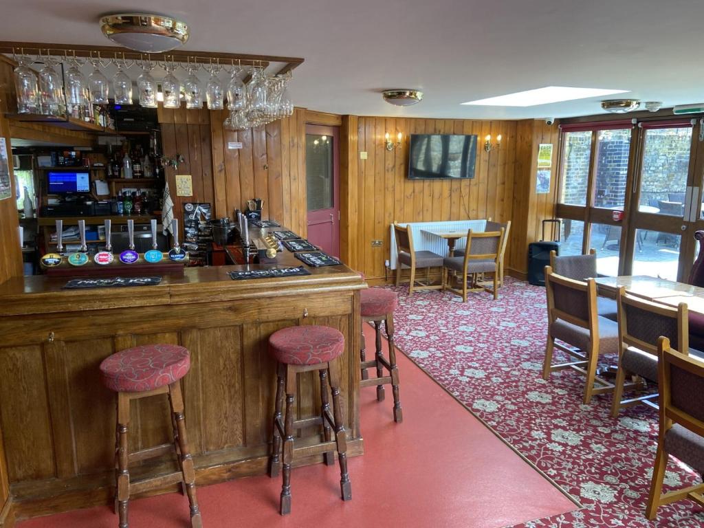 um bar num restaurante com cadeiras e uma mesa em The Jolly Drayman Pub and Hotel em Gravesend