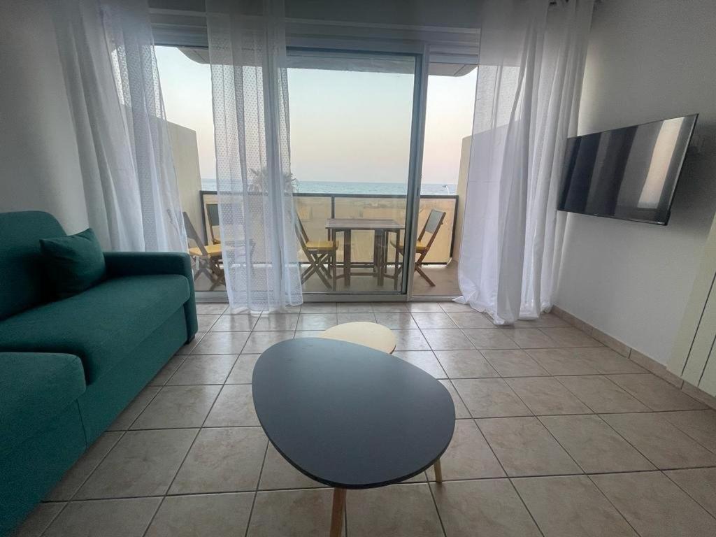 un salon avec un canapé et une table avec vue dans l'établissement Studio vue mer, ascenseur, parking - 4NOUM11, à Canet