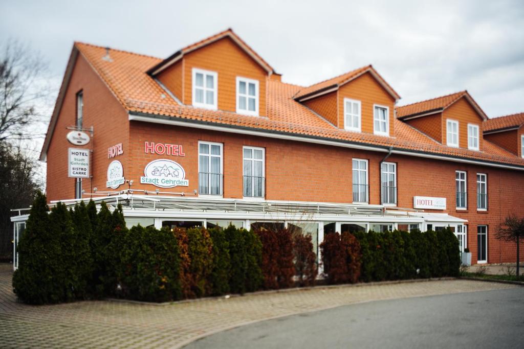 een groot gebouw van rode baksteen met een hotel bij Hotel Stadt Gehrden in Gehrden