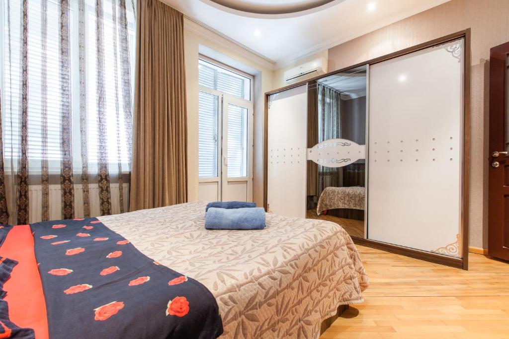 a bedroom with a bed and a large mirror at Sweet Home Apartment in Tbilisi City