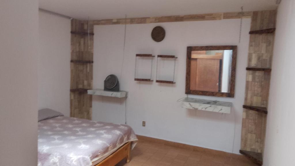 a bedroom with a bed and a mirror on the wall at Aguascalientes feria nacional de San Marcos in Aguascalientes