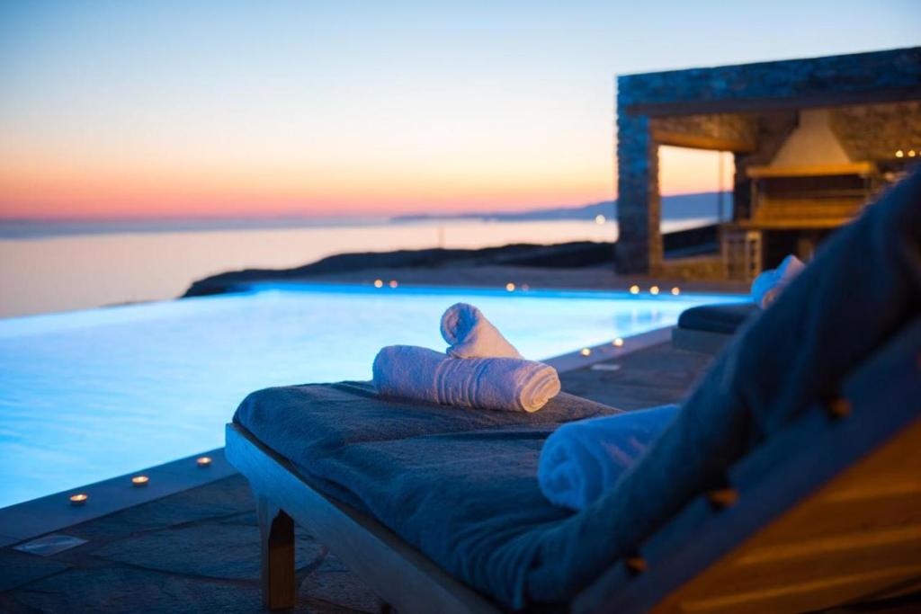 una piscina con asiento junto al agua en blue paradise villa, en Sifnos