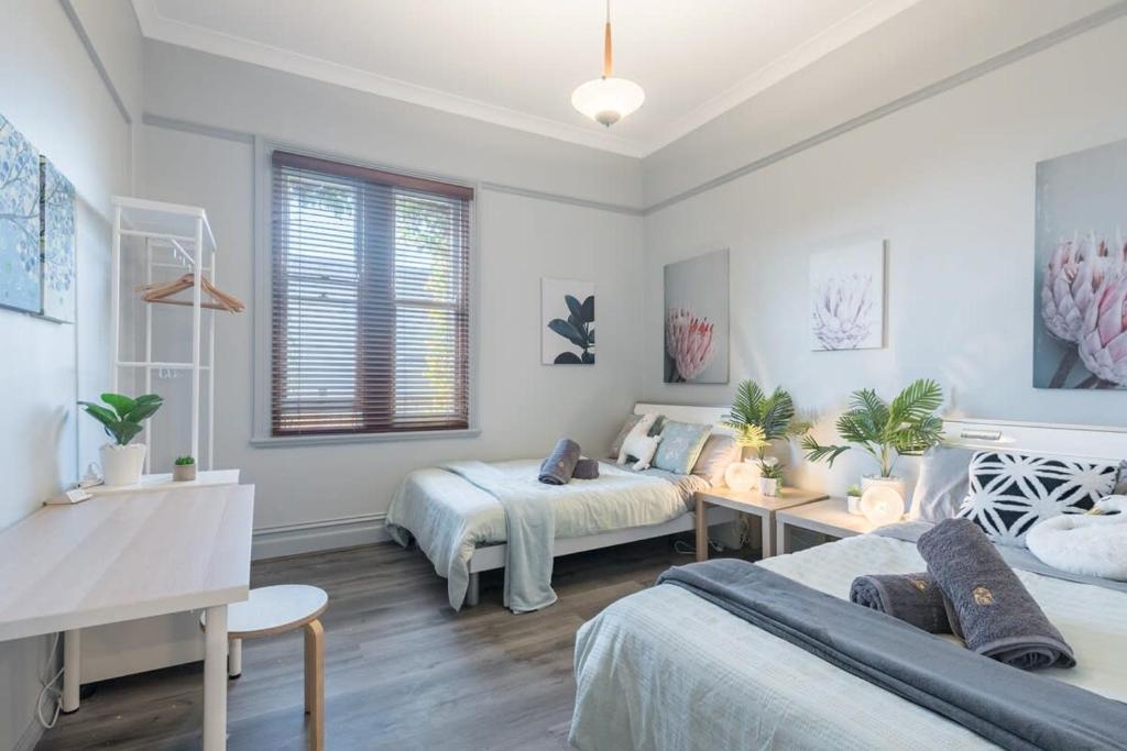 1 Schlafzimmer mit 2 Betten, einem Tisch und einem Schreibtisch in der Unterkunft Boutique Private Rm situated in the heart of Burwood 3 - ROOM ONLY in Sydney