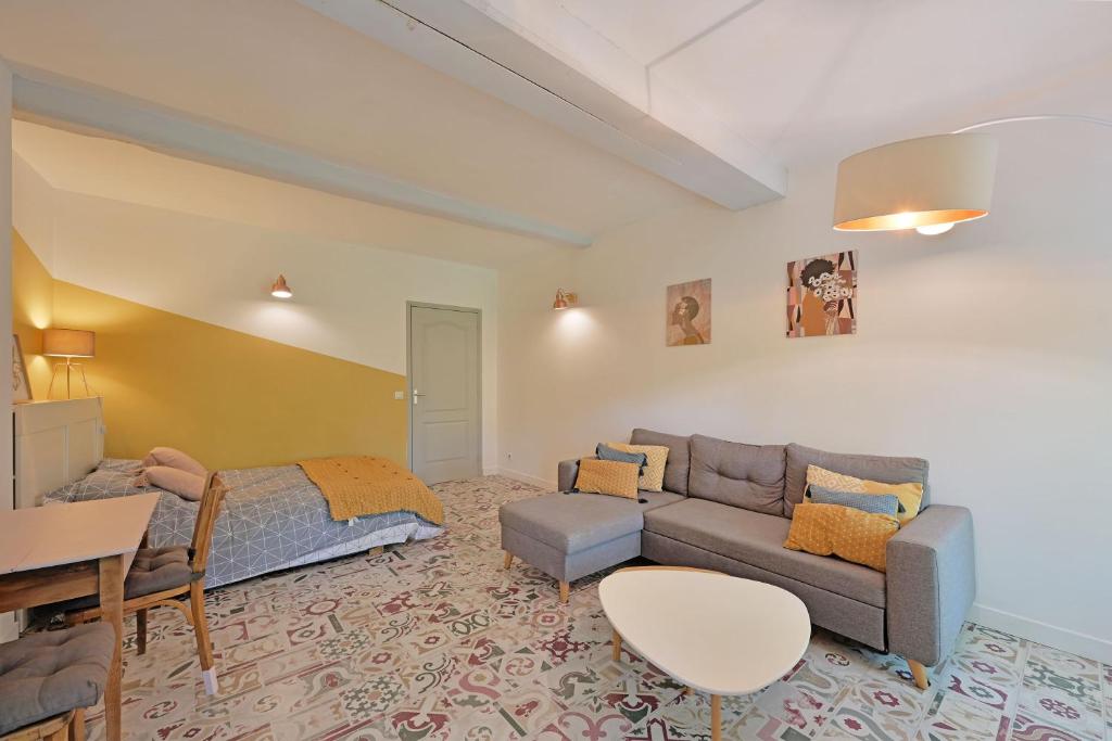 un salon avec un canapé et un lit dans l'établissement Le Balcon de l'horloge - AVIGNON - Centre ville, à Avignon