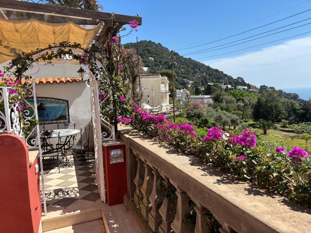 a balcony with purple flowers on a house at LUXURY House in VILLA POMPEIANA Via Camerelle con Terrazza Vista Mare in Capri