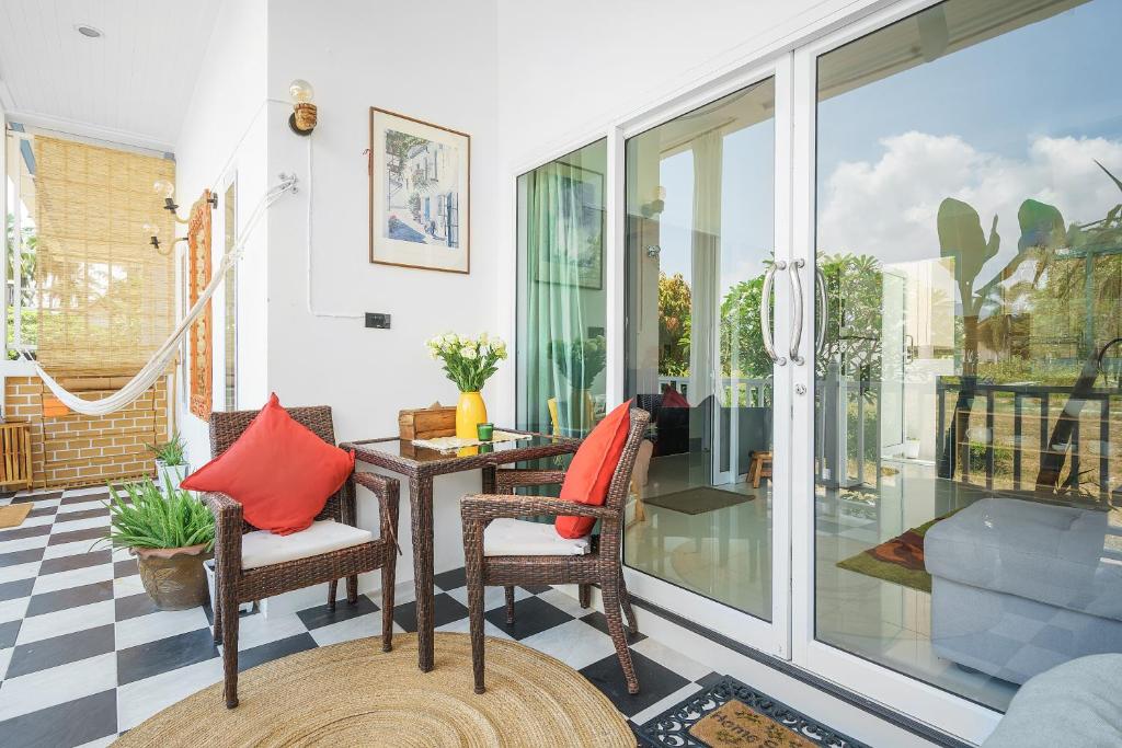 um quarto com uma mesa e cadeiras numa varanda em Sunset beach apartments 9 La Bella Villa em Ko Phangan