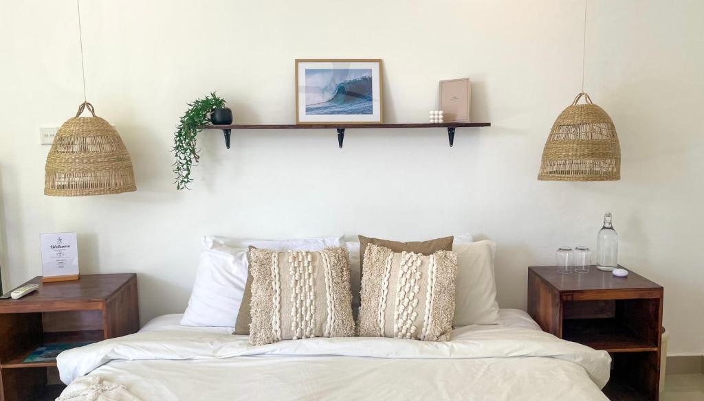 a bedroom with a bed with two shelves on the wall at Twin Palms Surfhouse in Thulusdhoo